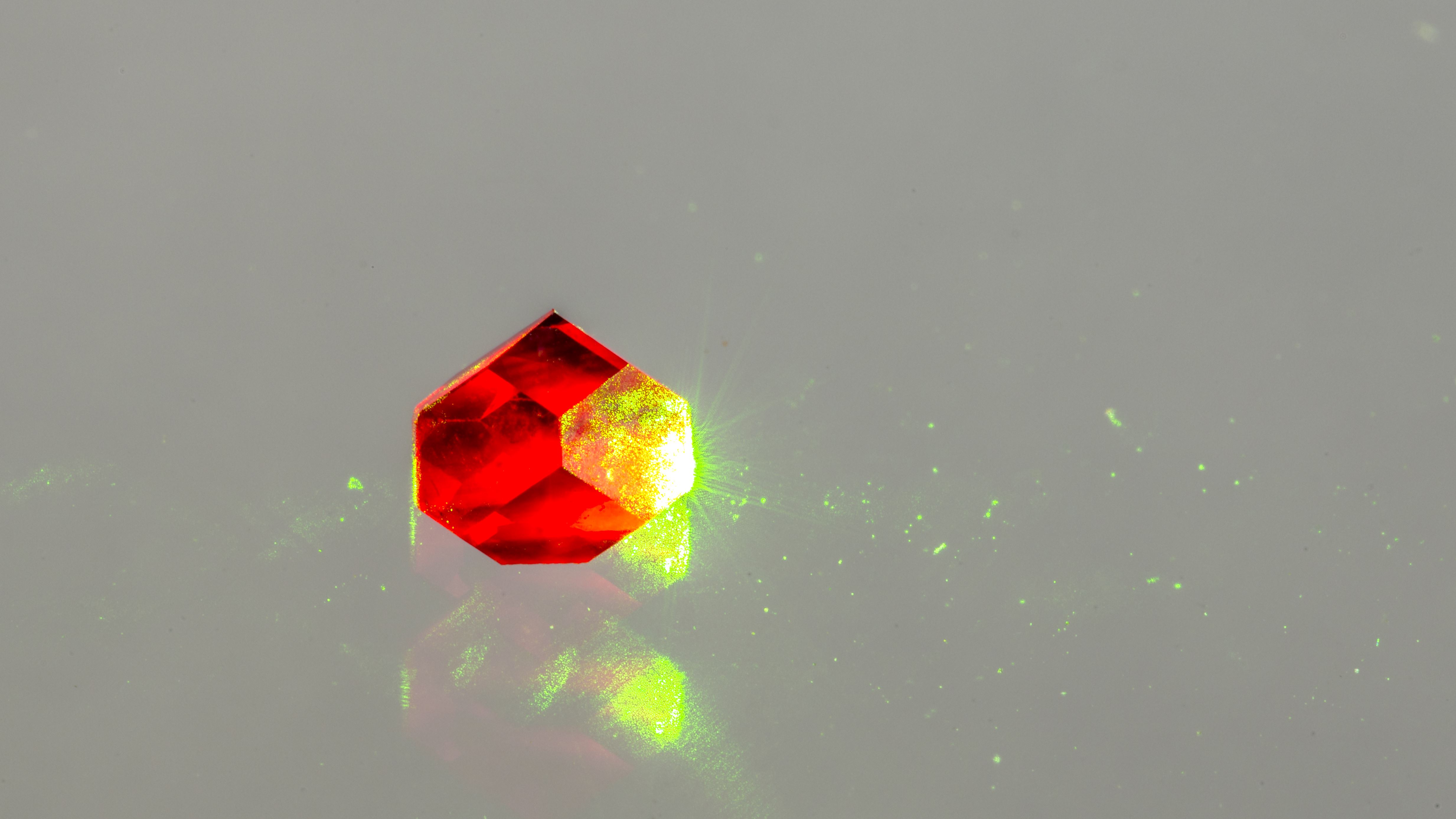 Photograph of diamond containing nitrogen vacancies fluorescing due to illumination with green light. Credit: Jon Newland